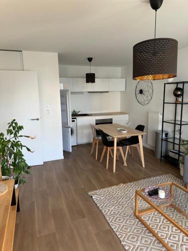 a living room with a table and a kitchen at Charming room Île de Nantes in Nantes