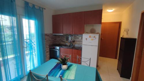 a kitchen with a blue table and a white refrigerator at Home Sweet Home Skala Fourkas in Skála Foúrkas