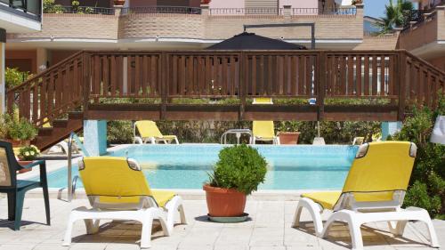 a group of chairs and a swimming pool at Villa Dei Romanzi in Tortoreto Lido