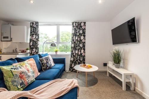 a living room with a blue couch and a table at KGV Stays Millbrook Executive Smart Corporate Apartment with Excellent City Links in Southampton