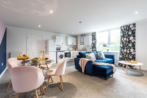a living room with a blue couch and a table at KGV Stays Millbrook Executive Smart Corporate Apartment with Excellent City Links in Southampton