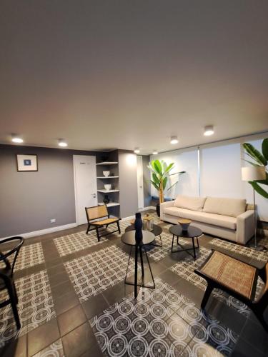 ein Wohnzimmer mit einem weißen Sofa und Tischen in der Unterkunft Departamento amoblado a pasos de ruta 5 con estacionamiento y WiFi in Coquimbo