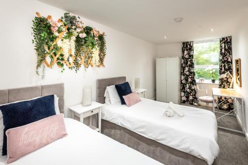a bedroom with two beds and a flower arrangement on the wall at KGV Stays Millbrook Executive Smart Corporate Apartment with Excellent City Links in Southampton
