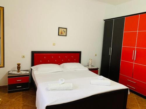 a bedroom with a large bed with red cabinets at Villa Gimi in Gjirokastër