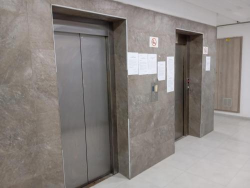 a row of elevator doors in a building at Magnifique appartement avec vue dégagée, près de l'aéroport et parking privé in Ariana