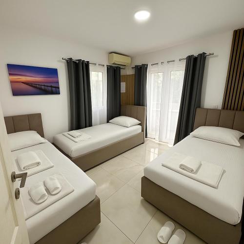 Zimmer mit 3 Betten und einem TV. in der Unterkunft Guest house, Small beach in Ulcinj