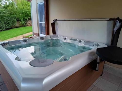 a jacuzzi tub in a yard with a stool in it at Szőlőszem Vendégházak in Szőlősgyörök