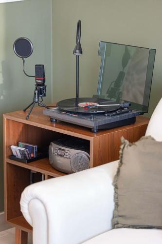 a tv on a wooden stand with a laptop on it at its the 90s - 120 inch screen in Yas Island