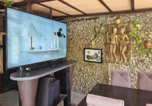 a large screen tv in a room with a wall at Chiang Ron in Chiang Mai