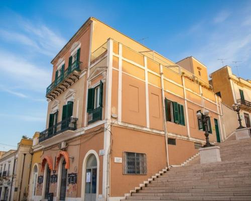 un edificio con scale di fronte a un edificio di B&B Le Colonne a Brindisi