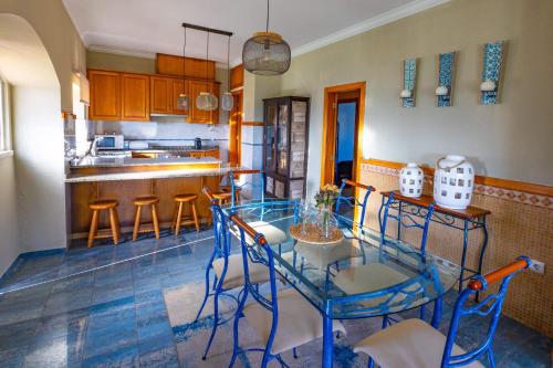 una cucina con tavolo in vetro e sgabelli di Casa De Campo Natureza a Porto de Mós