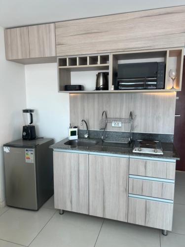 a kitchen with a sink and a refrigerator at ZONA VIP elegante y comodo APARTAMENTO FAMILIAR CON BALCON y hermosa vista a la calle, canal isuto zona equipetrol in Santa Cruz de la Sierra