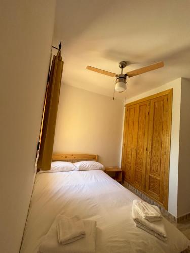 a bedroom with a bed and a ceiling fan at Apartamento Torres in Las Bombardas