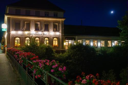 a building lit up at night with lights at Hotel Waibstadter Hof in Waibstadt