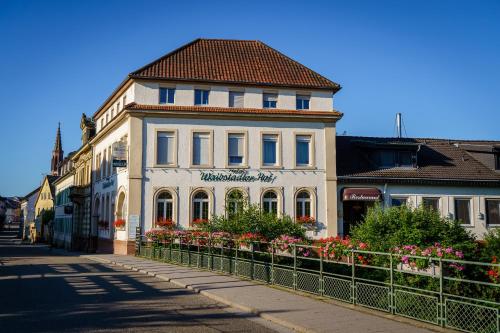 a white building with a red roof on a street at Hotel Waibstadter Hof in Waibstadt