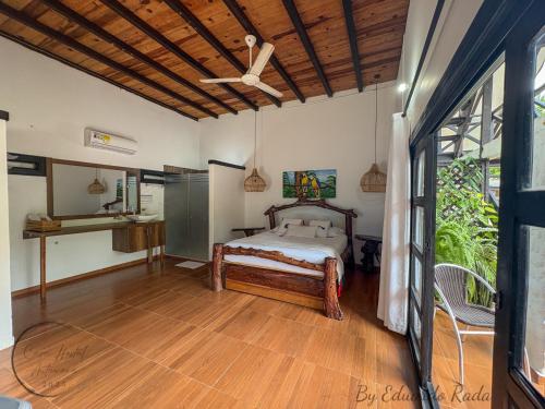 a bedroom with a bed and a ceiling fan at Hostal Antawara Tayrona in El Zaino