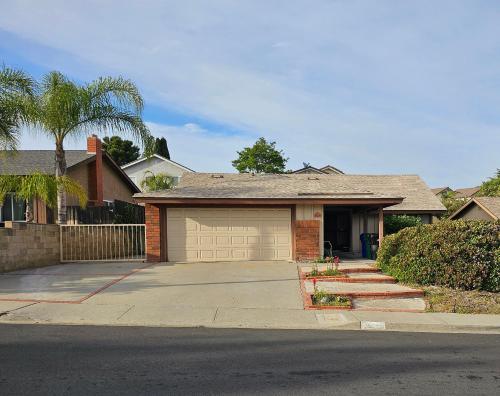 a house with a garage and a palm tree at Cat & Coffee Prime City Access - Room 1 in San Diego