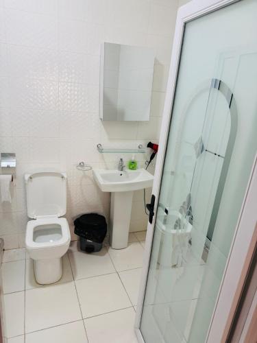 a bathroom with a toilet and a sink and a shower at Pebview 2 Bed Apartment in Kpone