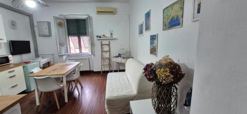 a kitchen and living room with a table and a desk at Maison 18 in La Spezia