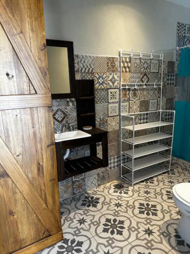 a bathroom with a toilet and a sink and a mirror at La Luján Ayres de Campo in Luján