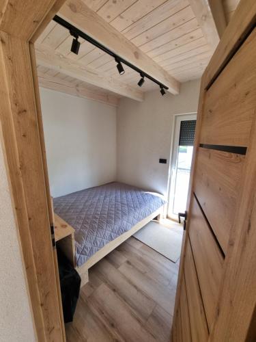 a bedroom in a tiny house with a bed at Przystań Lubie in Linowo