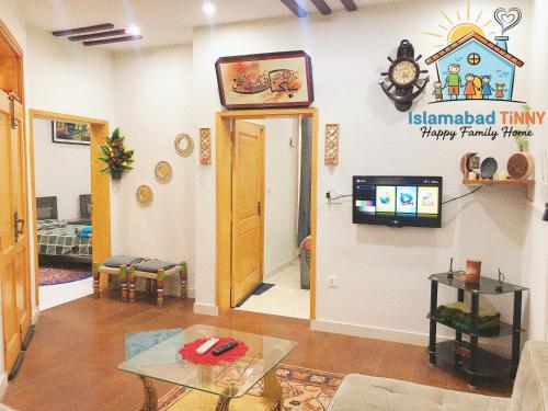 a living room with a clock on the wall at Islamabad Tinny Happy Family Home in Islamabad