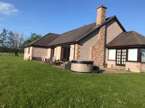 een huis met een grill voor een tuin bij Abalone Accommodation in Culbokie