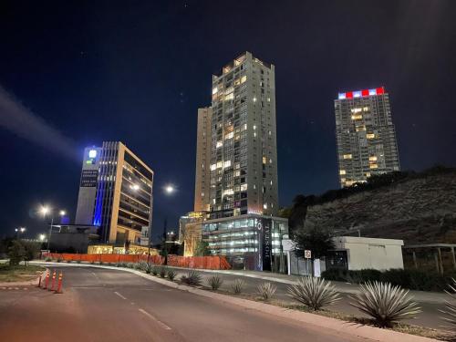 two tall buildings in a city at night at Motto, Queretaro Departamento in Miranda