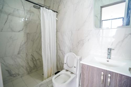 a white bathroom with a toilet and a sink at 1BR Amazing sea view in Calle 50 in Panama City