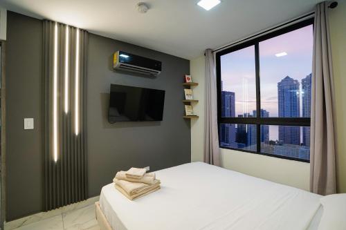 a bedroom with a bed and a tv and a window at 1BR Amazing sea view in Calle 50 in Panama City