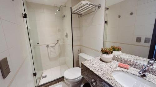 a bathroom with a toilet and a sink and a shower at Flat na Barra da Tijuca in Rio de Janeiro