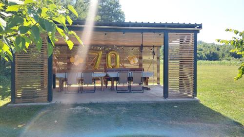 a wooden shed with a table and chairs in a field at Kovačnica 55 