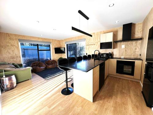 a kitchen with a counter and a living room at Rivers Edge Villa in Lake Tekapo