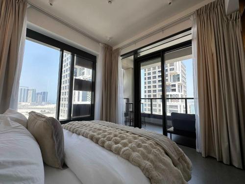 a bedroom with a large bed and large windows at Stylish Waterfront 1BR on Al Reem Island in Mushayrib