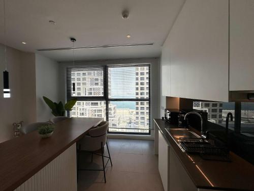 a kitchen with a counter and a large window at Stylish Waterfront 1BR on Al Reem Island in Mushayrib