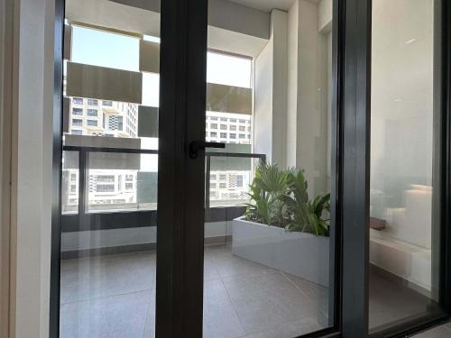 a sliding glass door with a plant in a room at Stylish Waterfront 1BR on Al Reem Island in Mushayrib