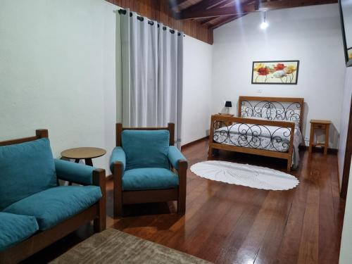 un salon avec deux chaises et un canapé dans l'établissement Sítio São João, à Córrego do Bom Jesus