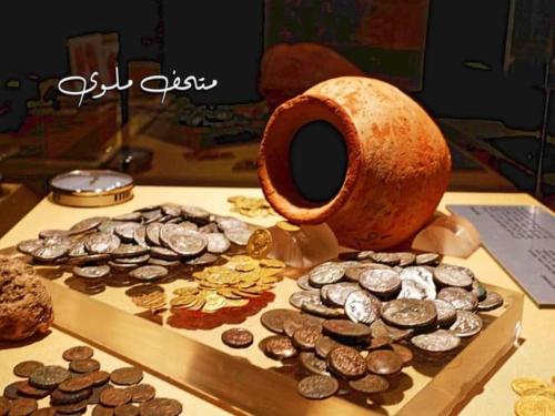 a table with a plate of coins and a vase at Apartment in Minya with archaeological tours in Al Minya