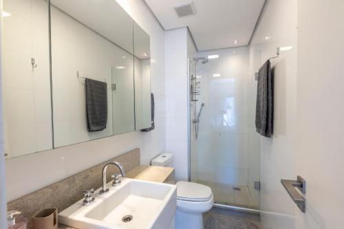 een badkamer met een wastafel, een toilet en een douche bij Apartamento top 40m2 Trend 24 Moinhos de Vento in Porto Alegre