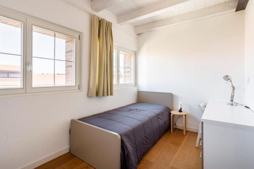 una camera da letto con un letto e una finestra di WAVE'S GLASS Industrial loft in old Murano a Venezia