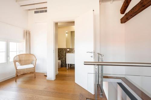 un corridoio bianco con sedia e finestra di WAVE'S GLASS Industrial loft in old Murano a Venezia