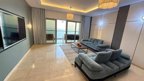 a living room with two couches and a table at شقة ثلاث غرف مطلة على البحر في برج داماك جدة in Jeddah