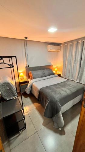a bedroom with a large bed and two lamps at Studio em Ponta Porã in Ponta Porã