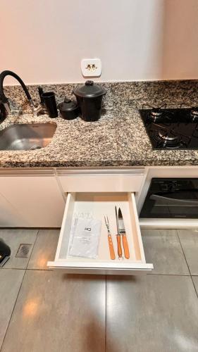 a counter with utensils on it in a kitchen at Studio em Ponta Porã in Ponta Porã