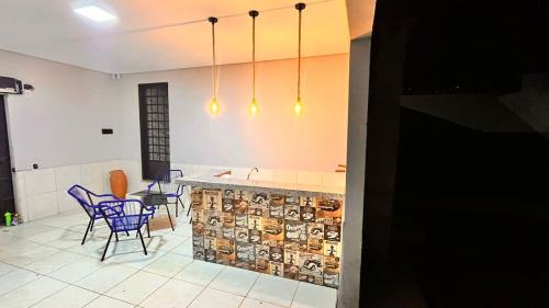 a kitchen with a table and chairs and lights at Studio em Ponta Porã in Ponta Porã