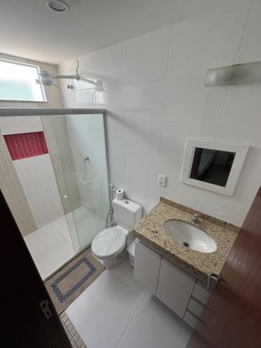 a bathroom with a toilet and a sink and a shower at Residence Villa Vignoli in Arraial do Cabo