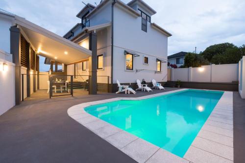 a swimming pool in front of a house at Coffs Jetty Beach House in Coffs Harbour