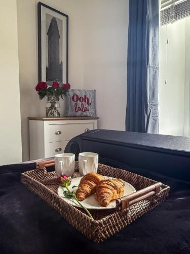 a tray with croissants and two cups on a bed at City Nights, TV Bed, Free Parking, Nr Plymouth Hoe in Plymouth