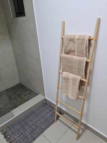 a towel rack with towels on it in a bathroom at Ocean Blue Villa, Flic-en-Flac in Flic-en-Flac