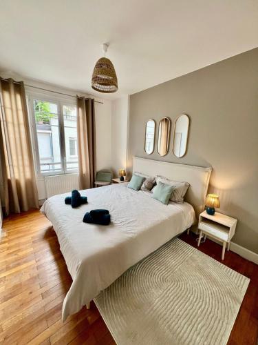 a bedroom with a large white bed with mirrors on the wall at Appartement élégant Championnet - 3 chambres - parking privé in Grenoble